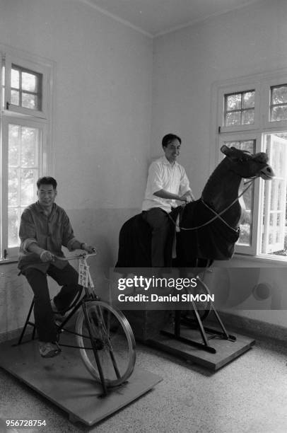 Entraînement à vélo et sur un faux cheval dans une salle de sport à Pékin en octobre 1983, Chine.