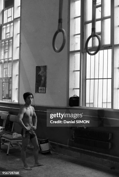 Un jeune homme lors de son entraînement aux anneaux dans une salle de sport à Pékin en octobre 1983, Chine.