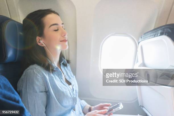 young woman relaxes during flight - window seat stock pictures, royalty-free photos & images