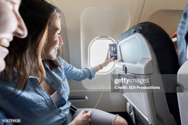 female friend take selfie on airplane - photo messaging stock pictures, royalty-free photos & images