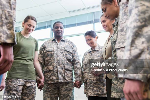 group of praying army soldiers - religious unity stock pictures, royalty-free photos & images