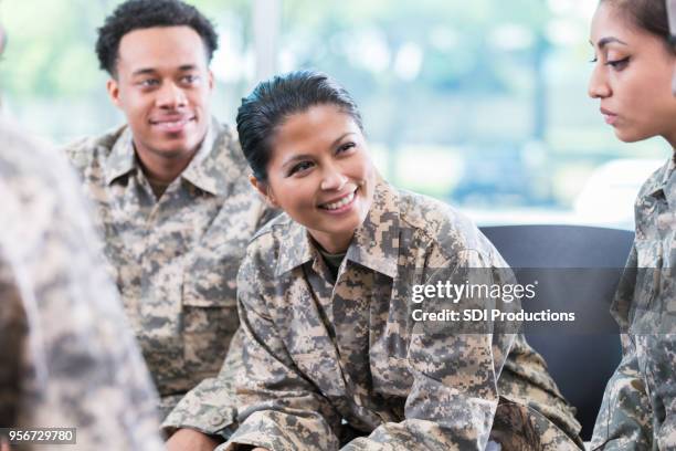 cheerful female veteran leads support group meeting - army woman stock pictures, royalty-free photos & images