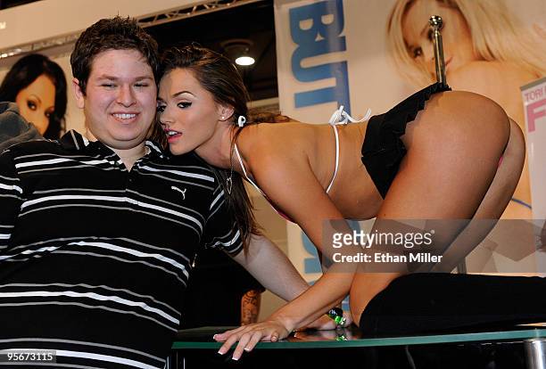 Attendee Jason Hashman of Canada takes a photo with adult film actress Tori Black at the Elegant Angel booth at the 2010 AVN Adult Entertainment Expo...