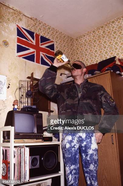 Un skinhead entrain de boire à la bouteille en novembre 1988 à Paris, France.