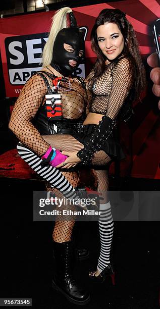 Maria Gara , a magician and snake handler known as SnakeBabe, poses with James "gspotlixalot" Duncan at the Sex App Shop booth at the 2010 AVN Adult...