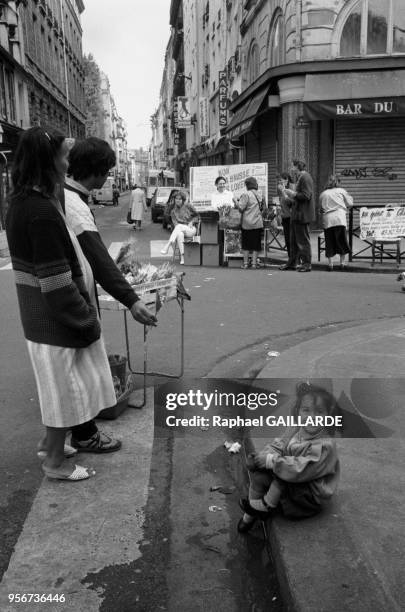 Fillette et vendeur du muguets le 1er mai 1987 à Paris, France.