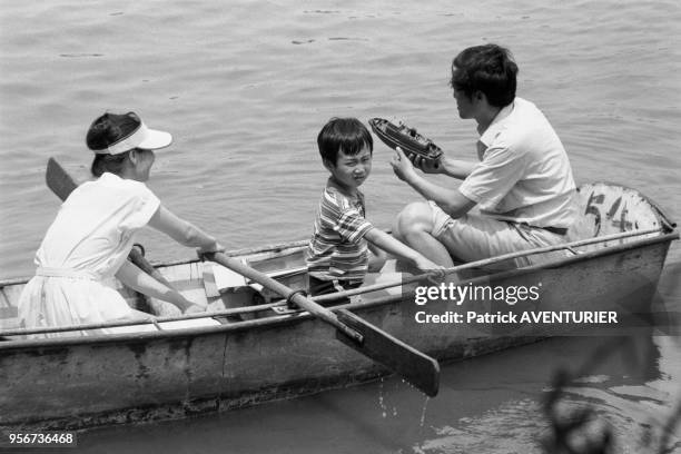 Un enfant et ses parents se prmènent en barque à Pékin en juin 1987, Chine.