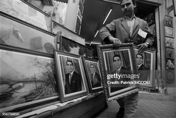 Un homme transporte des tableaux à l'effigie du président tunisien Ben Ali lors de sa prestation de serment à Tunis le 7 novembre 1987, Tunisie.