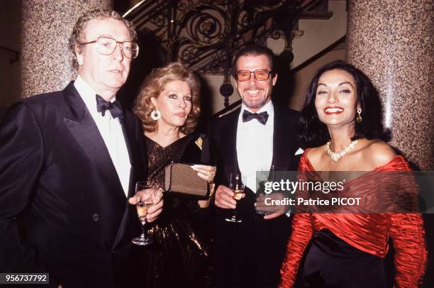 Michael Caine et Roger Moore et leurs épouses lors d'une soirée à l'Opéra Comique à Paris le 4 décembre 1990, France.