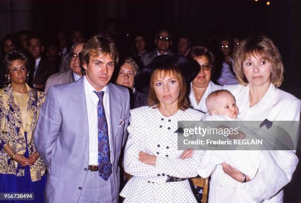 Les parents de Jeremy, François Valéry et Nicole Calfan, et leur enfant dans les bras de Mireille Darc en mai 1987 à Neuilly-sur-Seine, France.