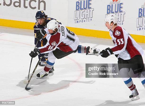 Darcy Tucker of the Colorado Avalanche has his shot blocked by Clarke McArthur of the Buffalo Sabres as Cody McLeod of the Avalanche looks on at HSBC...