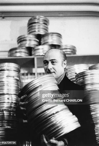 Le réalisateur Gérard Oury avec ses boîtes de bobines de films en décembre 1971 à Paris, France.