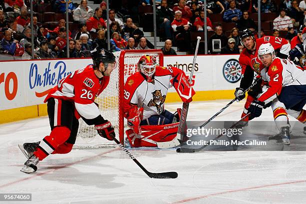 Ryan Shannon of the Ottawa Senators looks to make a pass to Mike Fisher while Tomas Vokoun and Keith Ballard of the Florida Panthers defend their net...