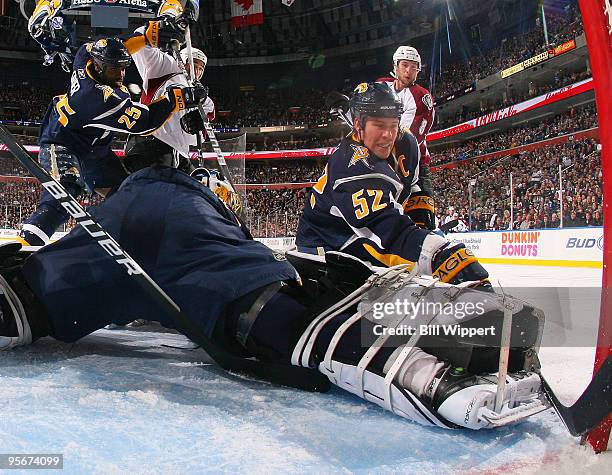 Michael Grier and Craig Rivet of the Buffalo Sabres help Sabres goaltender Patrick Lalime keep the puck out of the net during the Sabres game against...