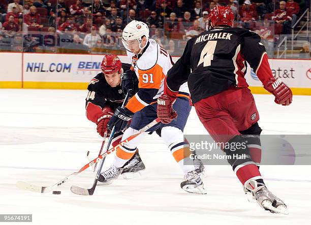 John Tavares of the New York Islanders skates with the puck against Taylor Pyatt and Zbynek Michalek of the Phoenix Coyotes on January 9, 2010 at...