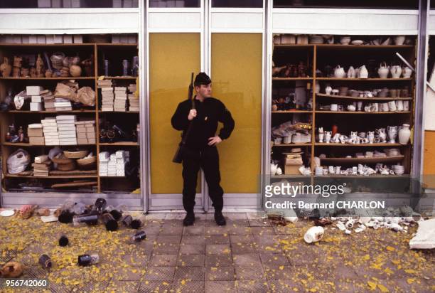 Un policier surveille un magasin endommagé par un engin explosif en 1981, France.