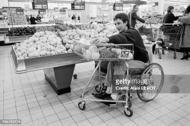 Une personne fait ses courses dans un supermarché Casino grace à un Caddie spécialement adapté pour les handicapés à Nantes le 6 avril 1988, France.