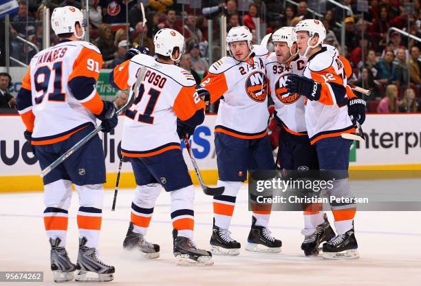 Mark Streit of the New York Islanders is congratulated by teammates John Tavares, Kyle Okposo, Doug Weight and Josh Bailey after Streit scored a...