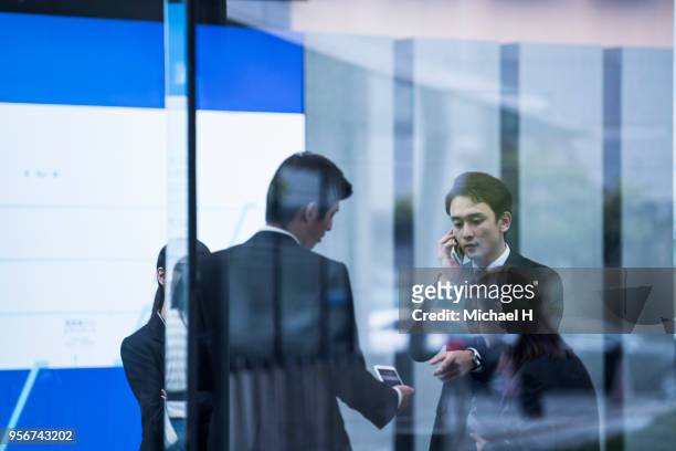 a young businessman is talking with a smile. - business smile stockfoto's en -beelden