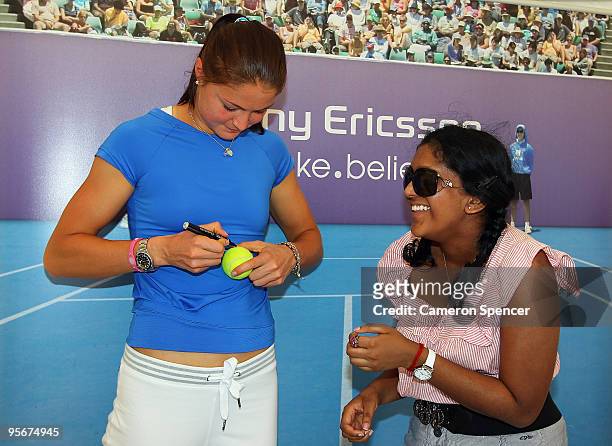 Dinara Safina of Russia signs a ball for a fan at an autograph session during day one of the 2010 Medibank International at Sydney Olympic Park...