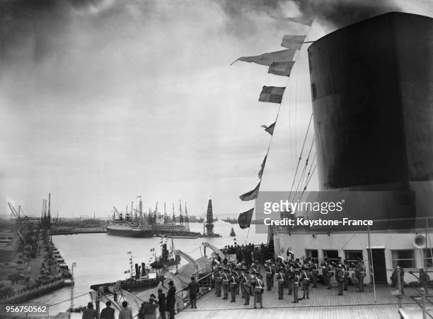 Sur le pont, au pied de la cheminée du 'Normandie', l'orchestre de la Garde américaine joue la Marseillaise à son arrivée au Havre, France en 1935.