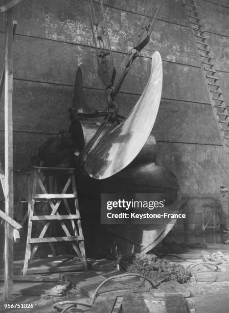 Ouvrier travaillant sur l'hélice du paquebot 'Normandie' en construction dans le chantier naval de Saint-Nazaire, France en 1935.