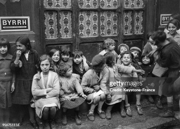 Enfants assis sur le trottoir à Marseille, France circa 1930.