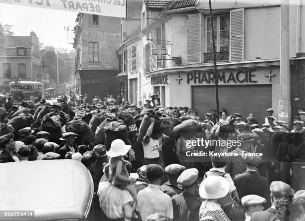 Course des charbonniers portant un sac d'anthracites sur le dos, la foule acclamme les participants, à Nanterre, France en 1935.
