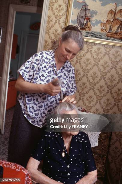 Aide à domicile coiffant une femme âgée à Vitry-sur-Seine, en juin 2004, dans le Val-de-Marne, France.