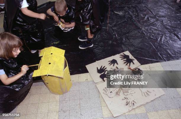 Enfants faisant de la peinture lors d'une colonie de vacances du Comité Central d'Entreprise de la SNCF à Clairoix, en 2001, dans l'Oise, France.