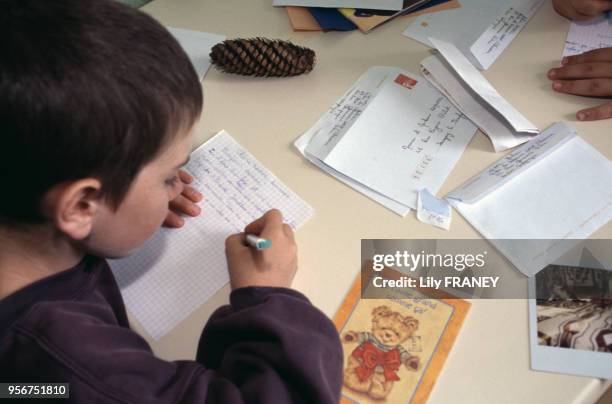 Enfant écrivant une lettre lors d'une colonie de vacances du Comité Central d'Entreprise de la SNCF à Clairoix, en 2001, dans l'Oise, France.