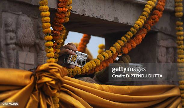 Indian monks stretch out their cameras to click a photograph of Tibetan spiritual leader The Dalai Lama during a special prayer session at The...