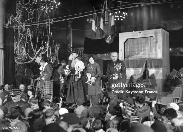 Le capitaine Villmain et le Père Noel distribuant des jouets lors du Noël des enfants à Paris, France, en décembre 1934.