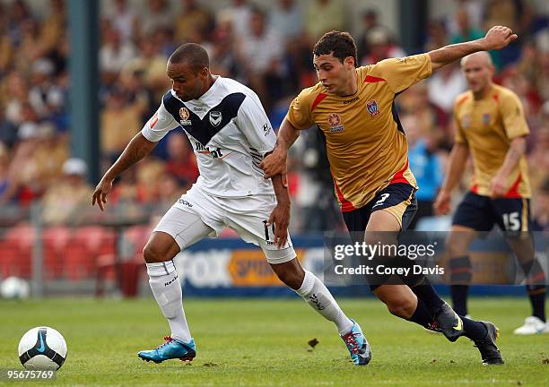 Archie Thompson of the Victory is challenged by Adam D'Apuzzo of the Jets during the round 22 A-League match between the Newcastle Jets and Melbourne...