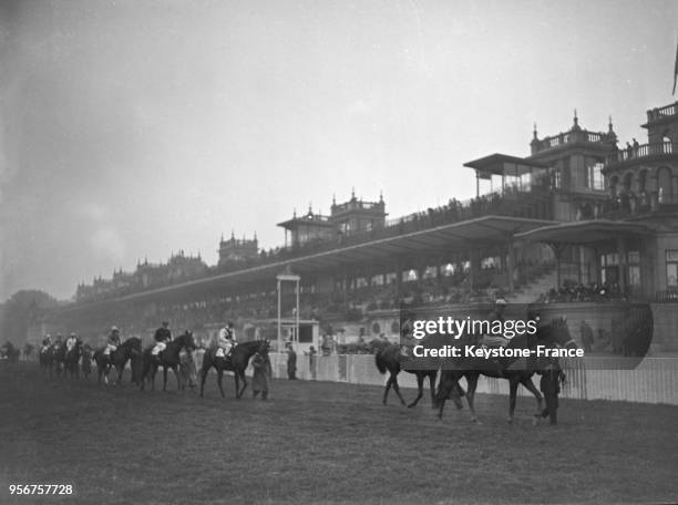 Défilé des chevaux avant la course hippique à l'hippodrome de Longchamp, à Paris, France circa 1930.