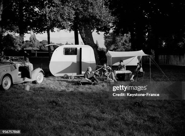 Des campeurs pique-niquent près de leur caravane au Bois de Boulogne en 1949 à Paris, France.