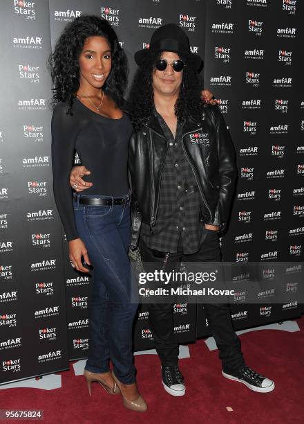 Musicians Kelly Rowland and Slash arrive at the amfAR Cocktail Party & PokerStars Red Carpet And Party at Aura Nightclub on January 9, 2010 in...