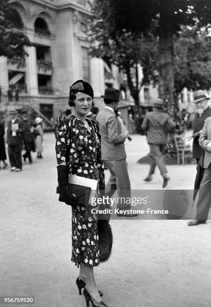 Belle création estivale portée par une jeune femme à l'hippodrome d'Auteuil, à Paris, France en juin 1933.