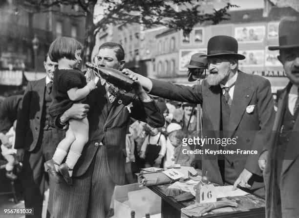 Le gagnant du 2e prix reçoit sa récompense au concours du plus bel enfant de Montparnasse, à Paris, France le 8 mai 1934.