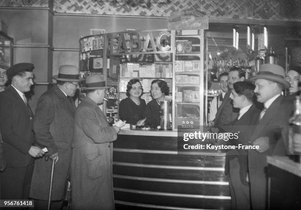 Le bureau de tabac de la rue des Archives où le gagnant anonyme du gros lot a acheté son billet de Loto, à Paris, France en 1934.