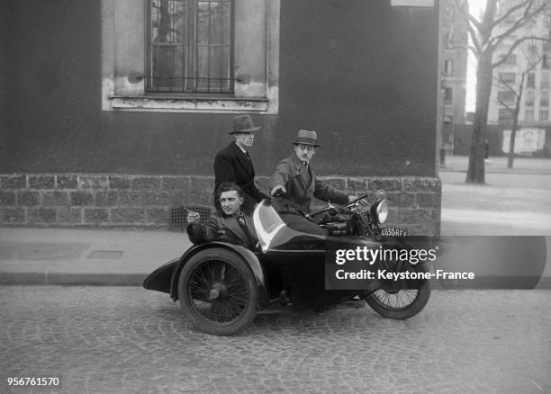 Un homme passe son permis de conduire moto, l'examineur installé dans le side-car, à Paris, France en 1934.