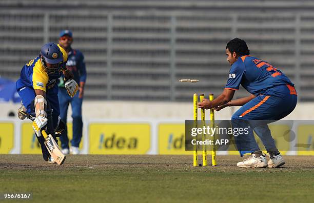 Indian cricketer Zaheer Khan stumps the wicket as Sri Lanka cricketer Thilina Kandamby drives during the Tri-Nation tournament One Day International...