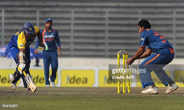 Indian cricketer Zaheer Khan stumps the wicket as teammate Virat Kohli looks on and Sri Lanka cricketer Thilina Kandamby places his bat during the...
