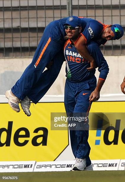 Indian cricketer Yuvraj Singh lifts his team mate Suresh Raina after the dismissal of Sri Lankan cricketer Thissara Pereraduring the Tri-Nation...