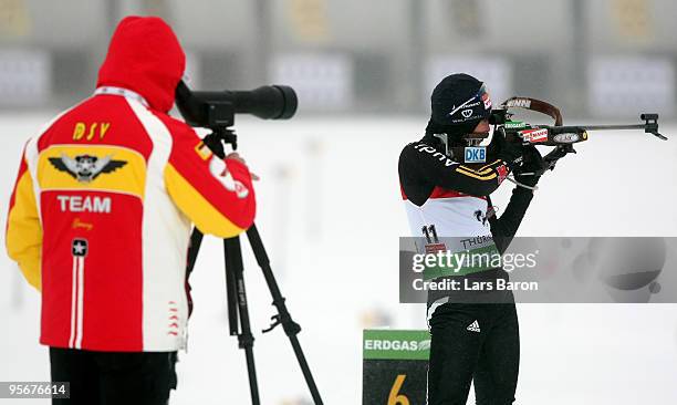 Head coach Uwe Muessiggang of Germany watches the shooting of Andrea Henkel of Germany prior to the Women's 12,5 km mass start in the e.on Ruhrgas...