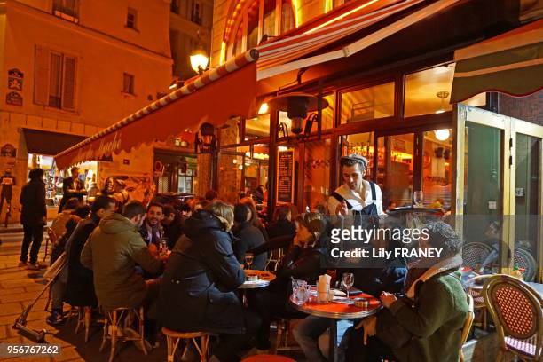 Café, terrasse dans la rue Buci, quartier de Saint Germain des près, le soir, 18 mars 2016, Paris, France.