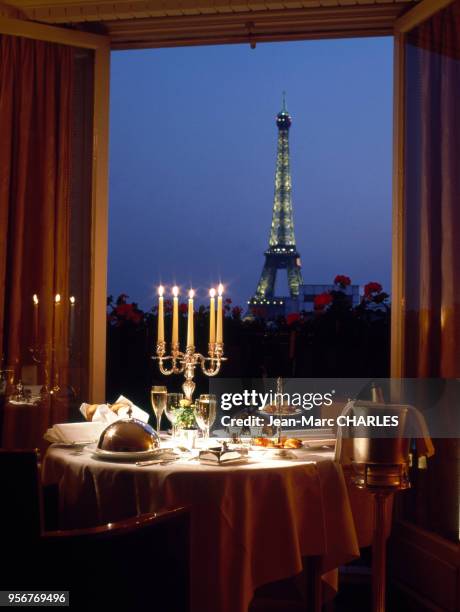 La Tour Eiffel vue depuis une chambre de l'hôtel Ritz dans laquelle une table a été dressée pour un dîner à Paris, France.