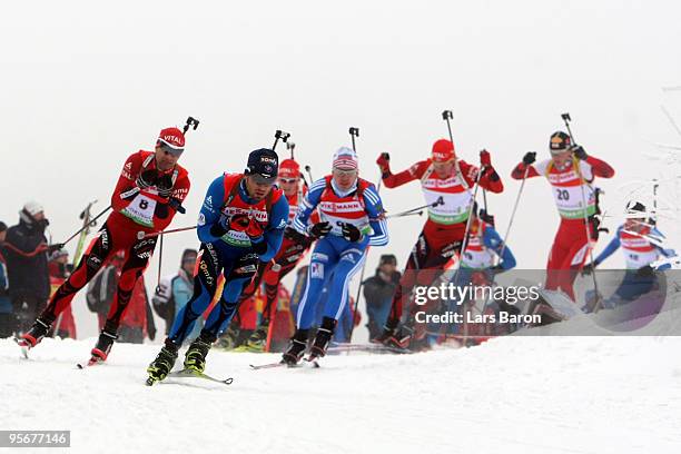 Simon Fourcade of France leads the pack into the first corner next to Ole Einar Bjoerndalen of Norway during the Men's 15 km mass start in the e.on...