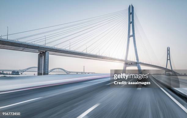 nanjing no.3 yangtze river bridge with blurred motion traffic - bridge stock pictures, royalty-free photos & images