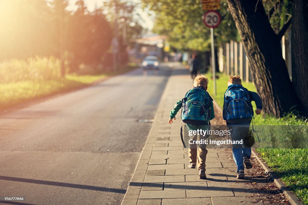 School boys running to school